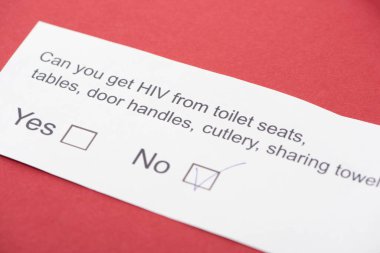  Kırmızı arkaplanda HIV anketi olan kağıt kart