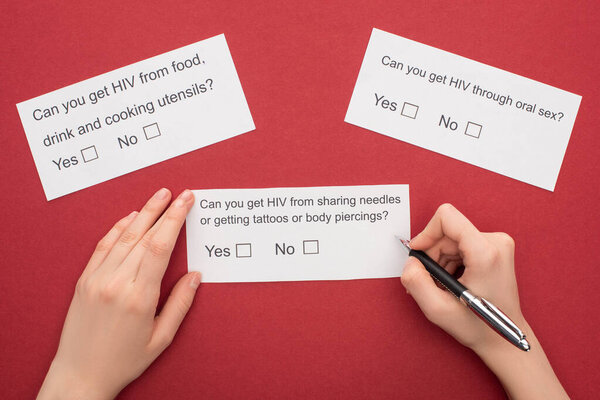 cropped view of woman answering HIV questionnaire on red background