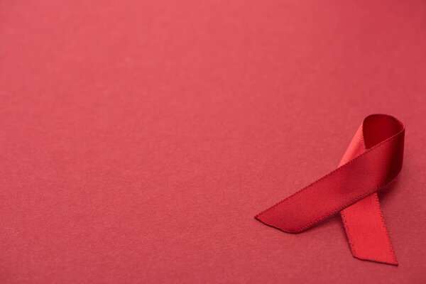 red awareness aids ribbon on red background