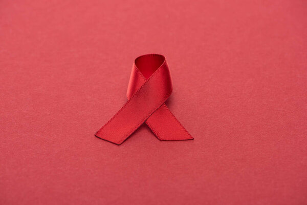 red awareness aids ribbon on red background