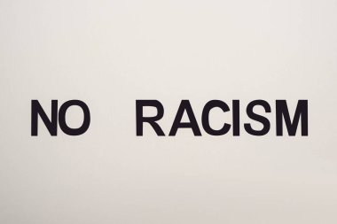 top view of black no racism lettering isolated on white clipart