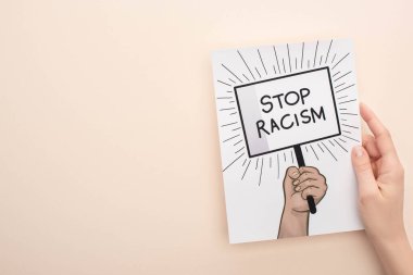 cropped view of picture with drawn hand and stop racism placard on beige background