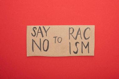 top view of carton placard with say no to racism lettering on red background clipart