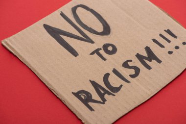 carton placard with say no to racism lettering on red background clipart