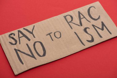 carton placard with say no to racism lettering on red background clipart