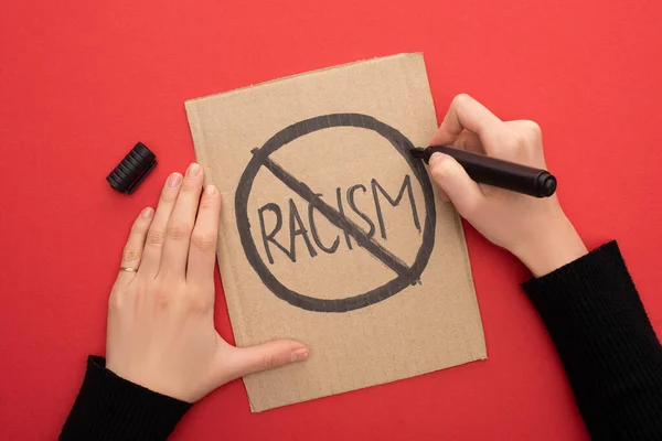妇女在红底纸板箱标语牌上印有 停止种族主义 标志的剪影 — 图库照片