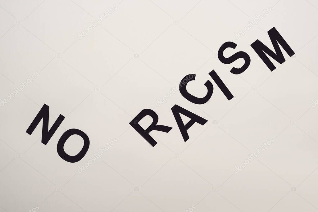 top view of black no racism lettering isolated on white