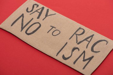 carton placard with say no to racism lettering on red background clipart