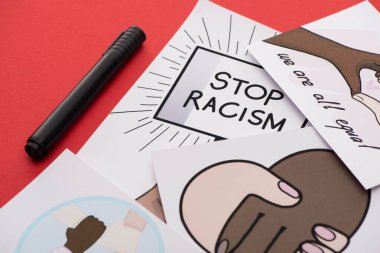 close up view of marker and pictures with multiethnic hands on red background clipart