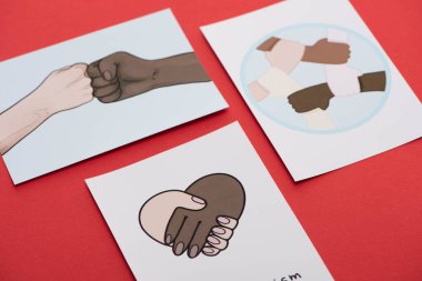 close up view of pictures with multiethnic hands on red background clipart