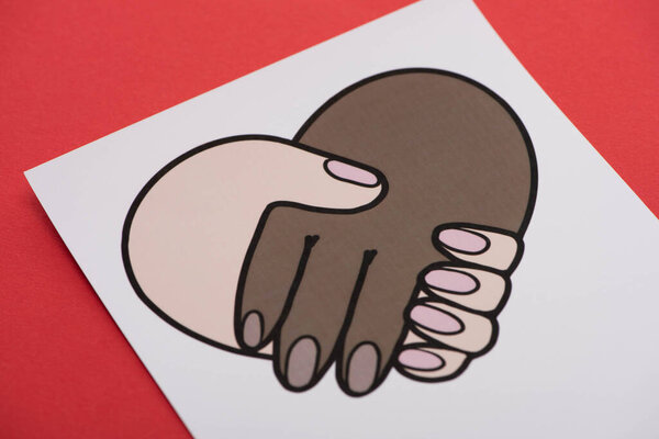 фотография с многонациональным рукопожатием на красном фоне
