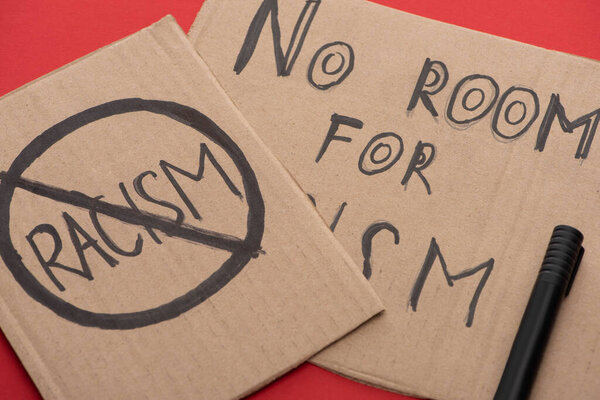 carton placards with stop racism lettering on red background