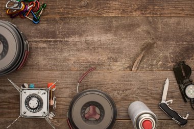 Ahşap yüzey üzerinde yürüyüş çanakları, gaz ocağı ve seyahat setinin üst görüntüsü