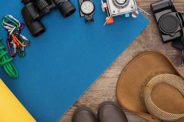 Draufsicht Auf Wanderausrüstung Auf Blauer Isomatte Fotokamera Stiefel Und Hut — Stockfoto