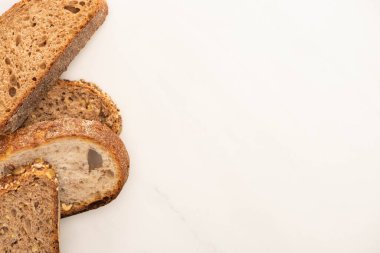 Beyaz zemin üzerindeki taze tahıllı ekmek dilimlerinin fotokopi alanı ile üst görünümü