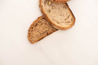Beyaz arkaplandaki leziz tam tahıllı ekmek dilimlerinin üst görünümü