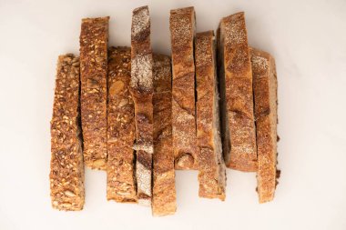Beyaz arkaplanda lezzetli kepekli ekmek dilimlerinin üst görünümü