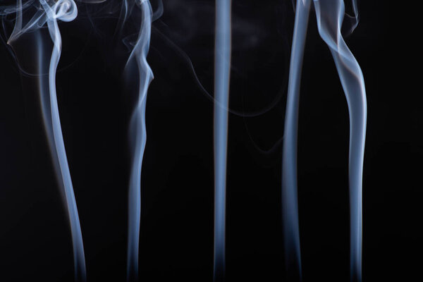 white flowing smoke steams on black background