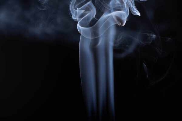 white flowing smoke on black background with copy space