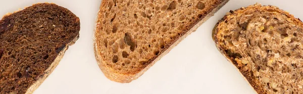 Вид Сверху Свежий Коричневый Хлеб Ломтики Белом Фоне Панорамный Снимок — стоковое фото