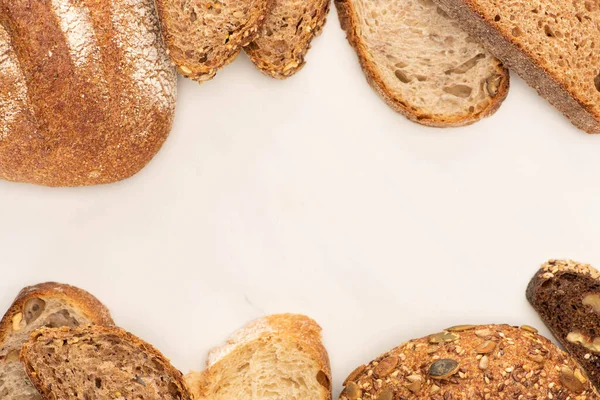 白色背景的新鲜棕色面包片和面包的顶部视图 — 图库照片