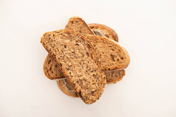 top view of fresh whole grain bread slices in stack on white background