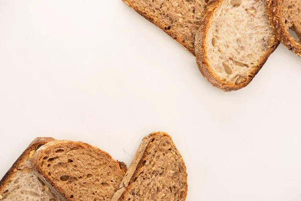 Bovenaanzicht Van Smakelijke Volkorenbrood Plakjes Witte Achtergrond Met Kopieerruimte — Stockfoto