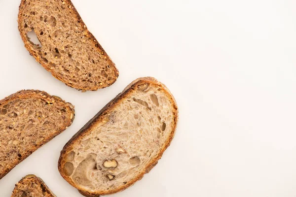 Bovenaanzicht Van Smakelijke Volkorenbrood Plakjes Witte Achtergrond Met Kopieerruimte — Stockfoto