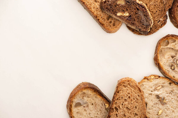 top view of tasty whole grain bread slices on white background with copy space