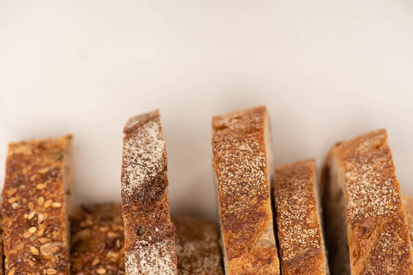 top view of tasty whole wheat bread slices with crust on white background with copy space