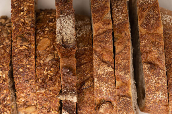 top view of tasty whole wheat bread slices with crust on white background