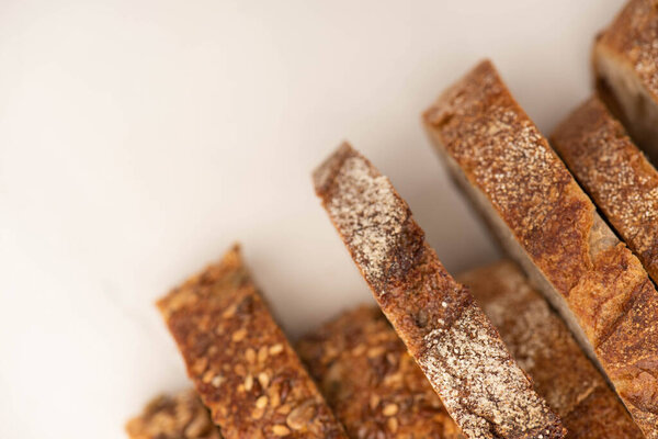 top view of tasty whole wheat bread slices with crust on white background