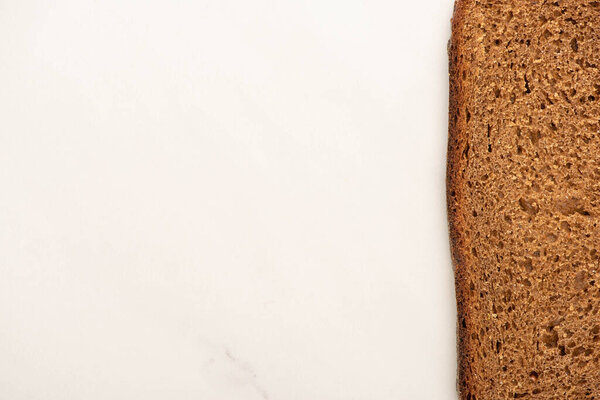 top view of fresh brown bread slice on white background with copy space