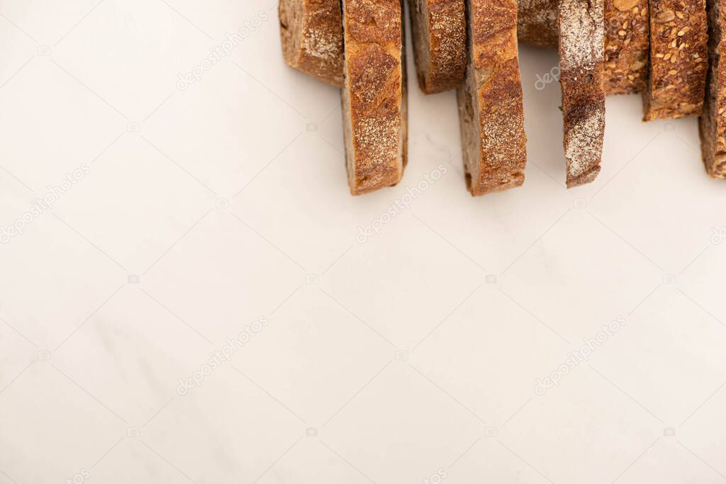 top view of tasty whole grain bread slices on white background with copy space