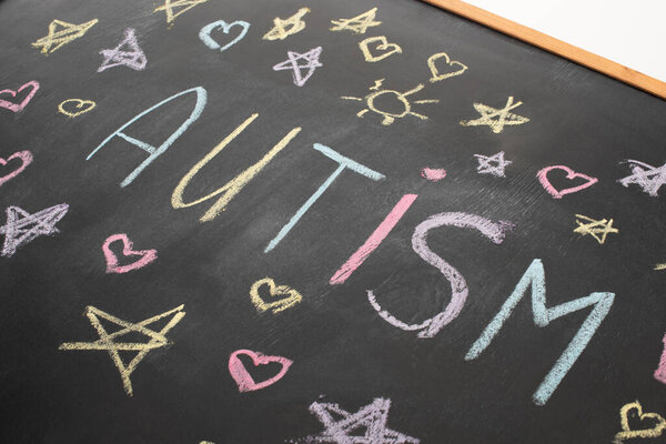 high angle view of chalkboard with word autism, hearts and stars drawings