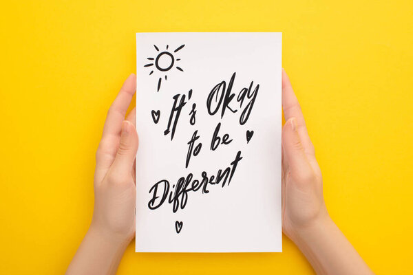 обрезанный вид лица, держащего лист бумаги с его нормально быть другой надписью на желтом
