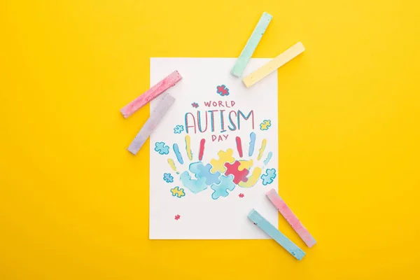 世界自闭症日卡片和手印的顶部视图 用黄色和粉笔隔开 — 图库照片