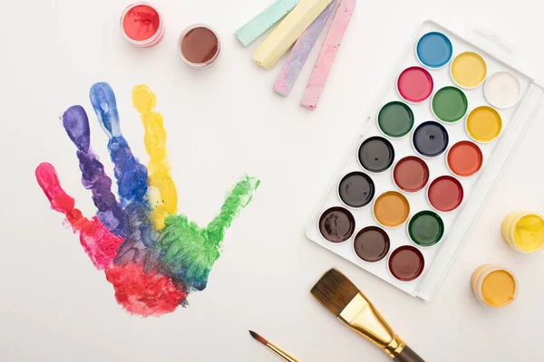 Draufsicht Auf Bunte Handabdrücke Kreiden Pinsel Und Farben Auf Weiß — Stockfoto