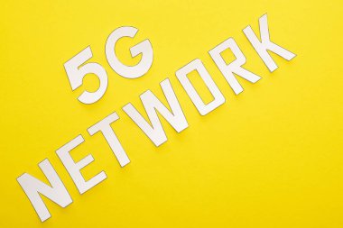 Sarı arkaplanda beyaz 5 G ağ harflerinin üst görünümü