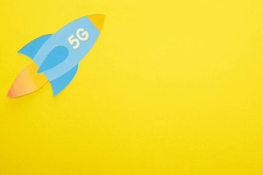 Sarı arkaplanda 5 G harfli kağıt roketin üst görünümü