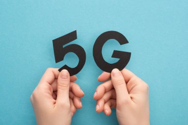 Kırpılmış mavi arka planda siyah 5 G harfli kadın manzarası