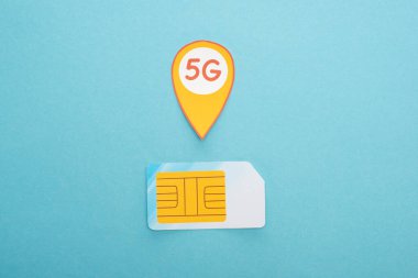 Sim kartın üst görünümü ve mavi arkaplanda 5G harfleri