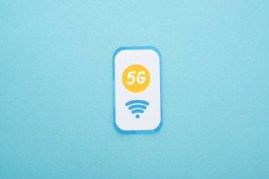 top view of 5g lettering on paper smartphone on blue background clipart