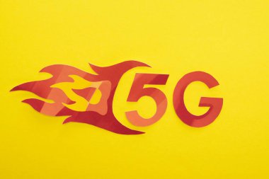 Sarı arkaplanda alev harfleri olan kırmızı 5 G 'nin üst görünümü