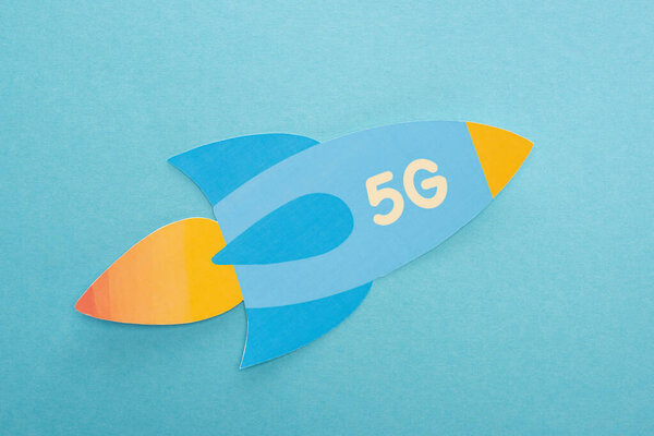 top view of paper rocket with 5g lettering on blue background