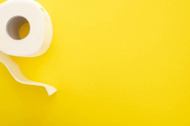 top view of white toilet paper roll on yellow background clipart