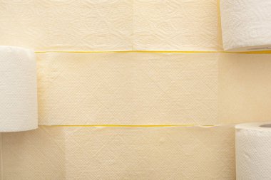 Sarı zemin üzerinde beyaz tuvalet kağıdının üst görüntüsü