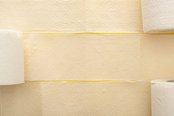 top view of unrolled white toilet paper on yellow background