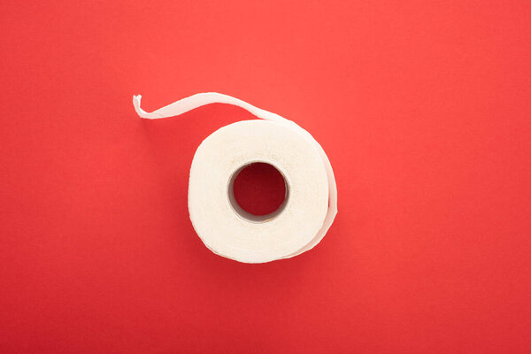 top view of white toilet paper roll on red background