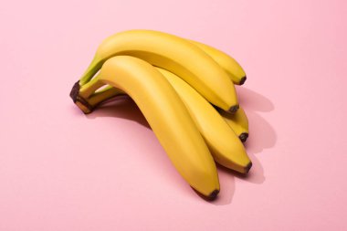 High angle view of ripe yellow bananas on pink background clipart